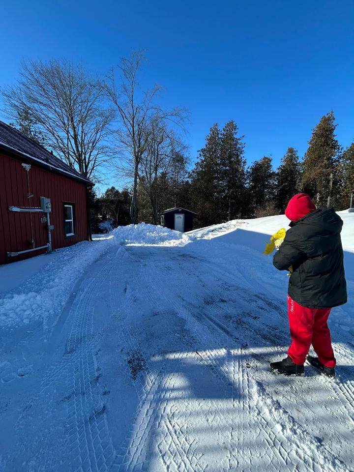SnowBROS crew hand-salting a country driveway after a plow pass