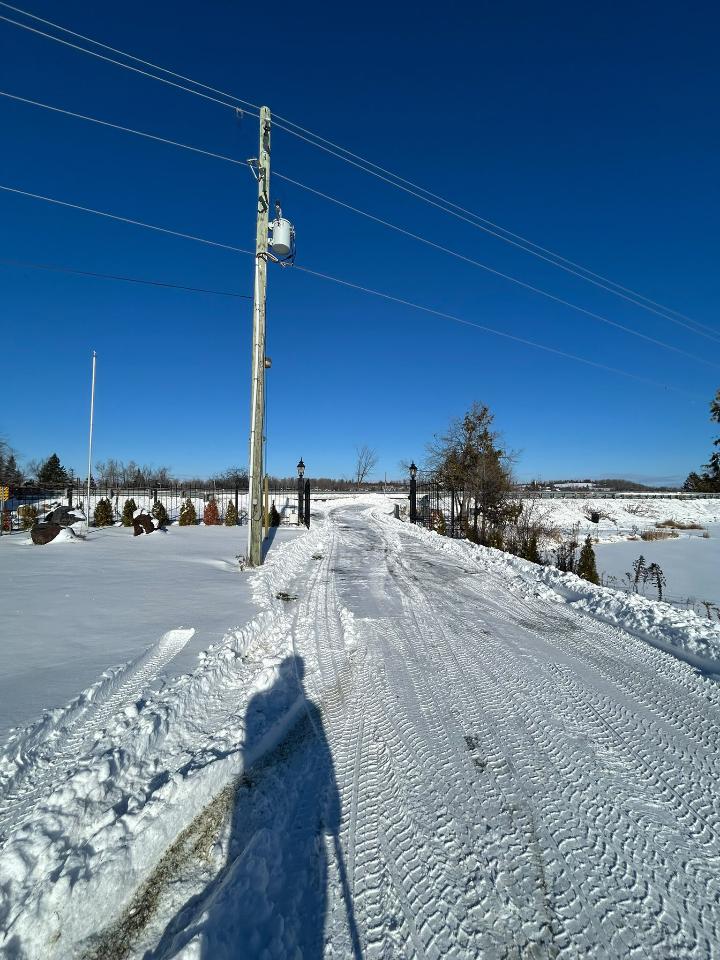 Long rural gated laneway cleanly plowed edge-to-edge